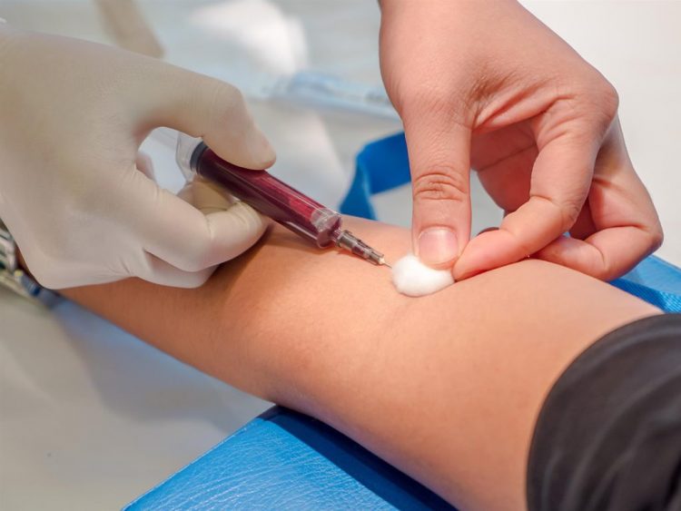 Các chuyên viên y tế đang thực hiện quá trình lấy máu để đem đi xét nghiệm